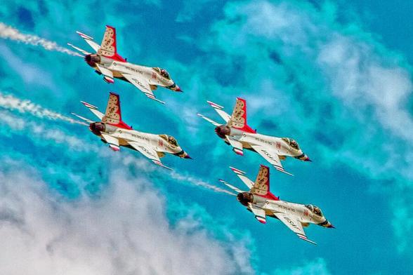 Thunderbirds In Formation II

This is an image of the precision flying team, the USAF Thunderbirds flying in formation over Traverse Air Force Base in Fairfield California. .
The jets had just passed overhead from over my left shoulder banking hard right in a diamond formation. The jets are painted white with the red and blue trim on the nose, tail, and wings. 
The sky is partially cloudy behind the jets. 
I have processed this in a painterly fashion.