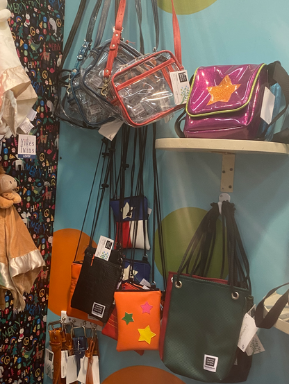 Vending booth display of brightly colored vinyl purses and bags by Nakatsu by JNA Designs