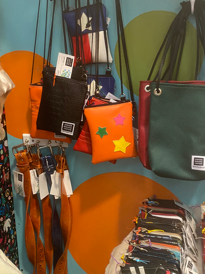 Vending booth display of brightly colored vinyl purses and bags and belts by Nakatsu by JNA Designs