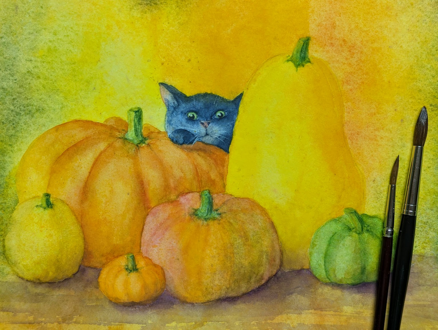 A small black cat peeks curiously out from behind a group of colorful pumpkins and gourds. The pumpkins come in different shapes, colours and sizes. Only the head and one front paw of the cute kitten behind it can be seen. The cat seems to enjoy playing hide and seek.
The bright warm colors create a cozy and playful autumn atmosphere.
Black cat peeking behind pumpkins is a hand-painted watercolour by artist Karen Kaspar. It is perfect for autumnal home decoration and for anyone who likes cute rather than scary images for Halloween.