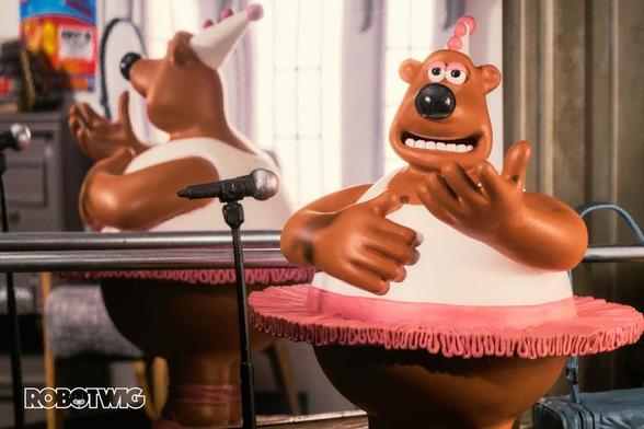 Alvin the dancing bear wears a tutu and talks into a microphone in a dance hall discussing his favourite ways to work out