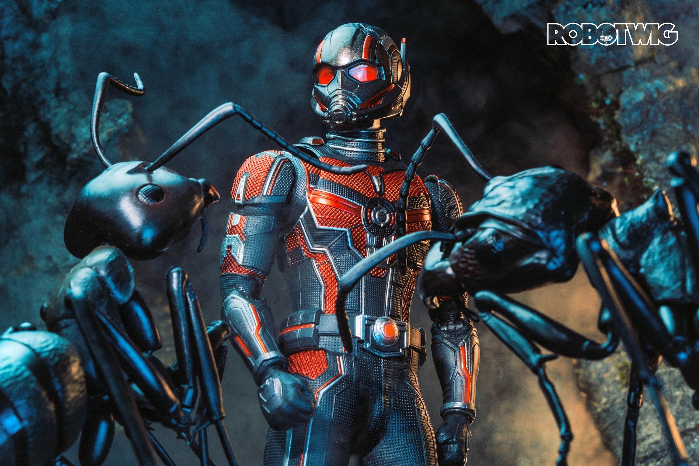 Ant man stands in an underground tunnel surrounded by ants