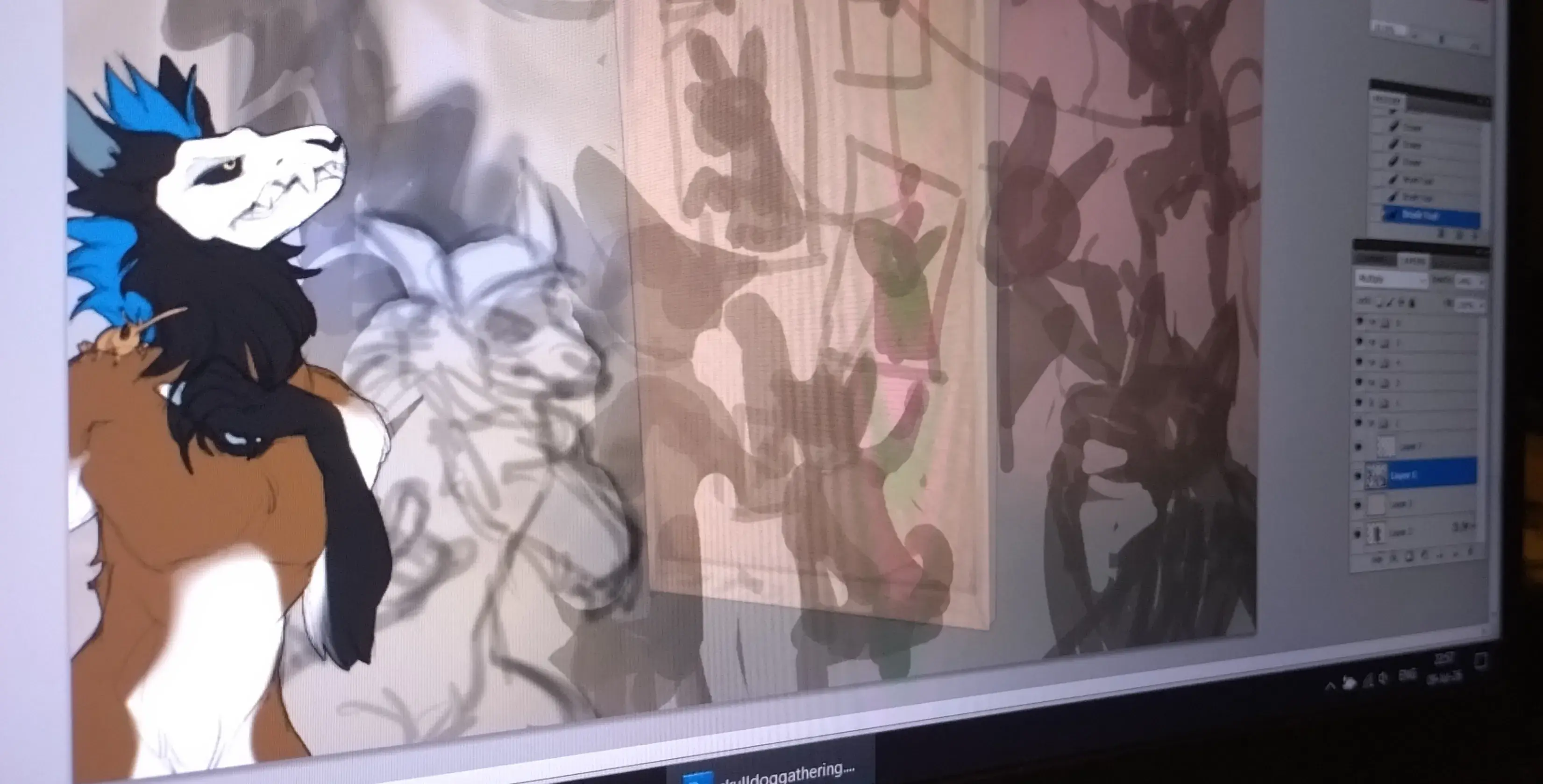 Photo of a PC screen with a work I progress sketch, of multiple skulldog characters.