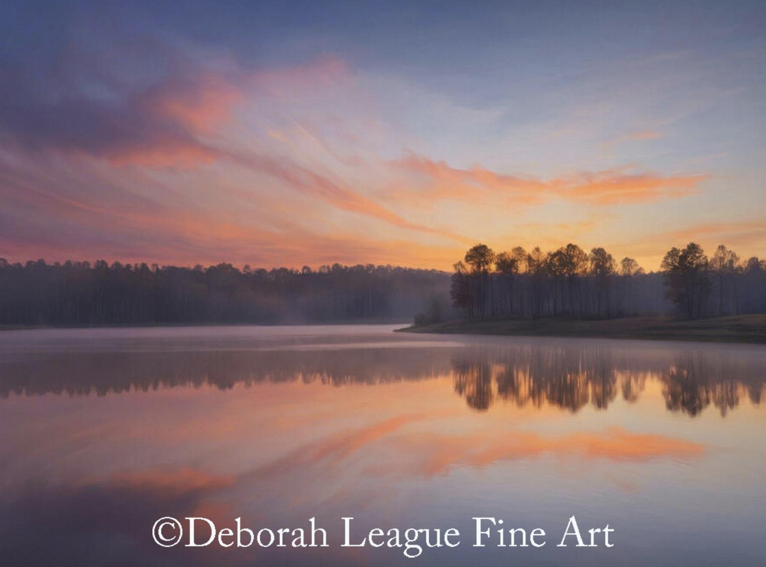 Soft pastel clouds sweep across the sky as dawn breaks over a tranquil lake, their warm hues mirrored perfectly in the still water below. A delicate veil of morning mist drifts along the tree-lined shore, creating a quiet, contemplative atmosphere that evokes peace, balance, and renewal.

This serene landscape artwork captures the fleeting beauty of sunrise reflections, blending gentle pinks, oranges, and cool blues in a harmonious composition. Ideal for collectors and interior designers, this calming nature scene brings a sense of openness and serenity to living rooms, bedrooms, offices, and wellness spaces.

Perfect as wall art for modern, minimalist, and nature-inspired interiors, this timeless sunrise landscape invites the viewer to pause, breathe, and connect with the quiet rhythms of the natural world.

Style: Fine art landscape photography, contemporary nature photography, minimalist landscape, atmospheric photography.

Theme: Sunrise, peaceful lake, morning mist, reflections, tranquility, mindfulness, natural beauty, serenity.

Color Palette: Soft pink, coral, peach, lavender, warm gold, misty blue, slate blue, charcoal silhouettes.