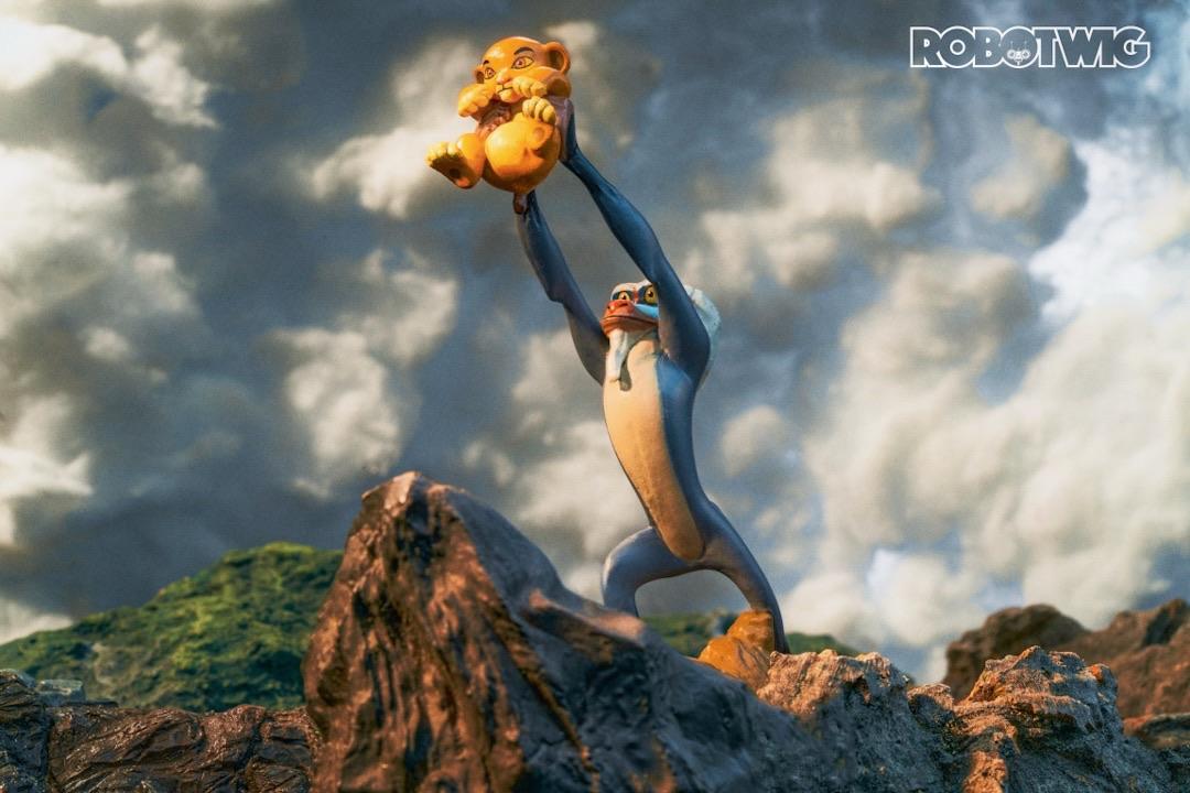 Rafiki stands atop pride rock and holds baby Simba in his hands and holds him up to the sky in a recreation of the iconic shot from the lion king