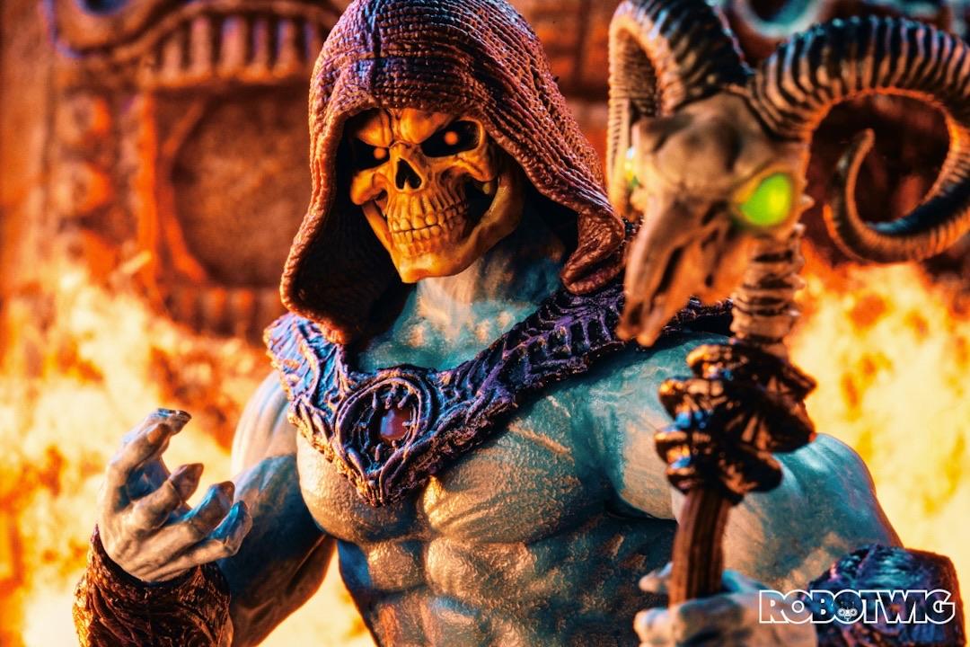 Skeletor stands in front of inferno holding his staff towards the camera