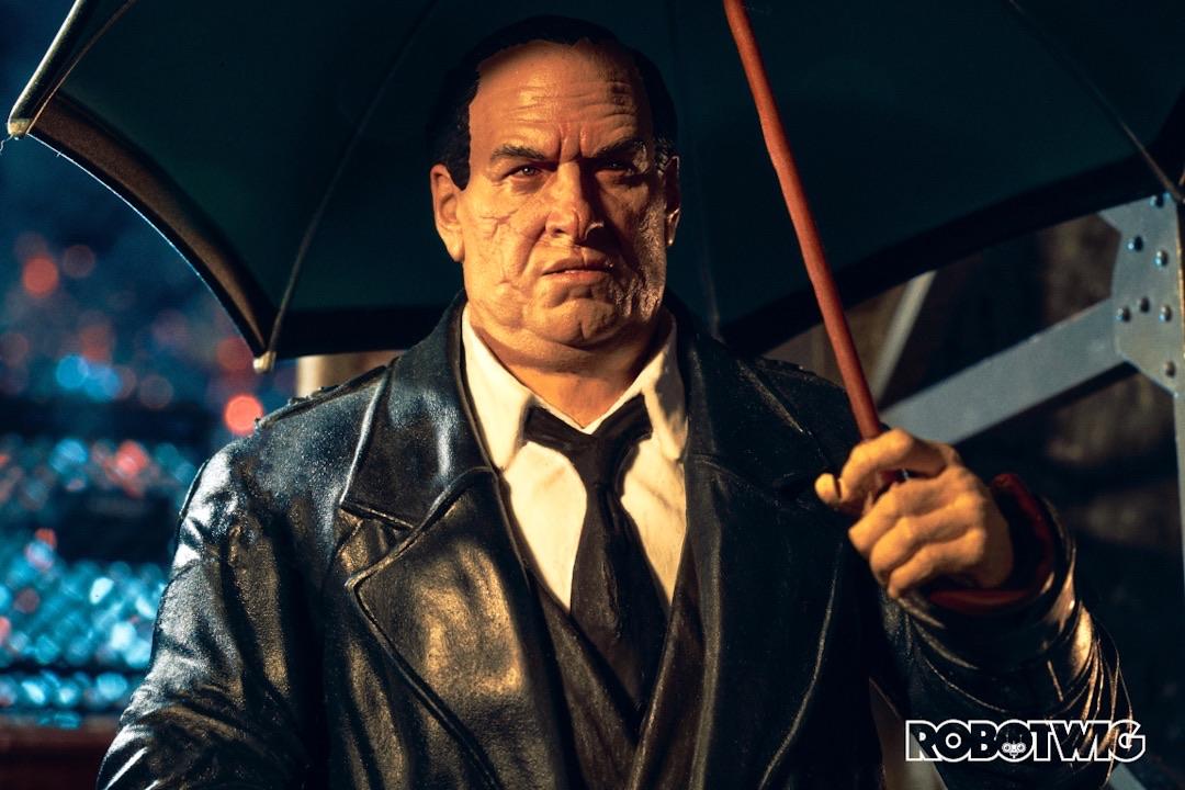 Oz Cobb stands outside holding an umbrella