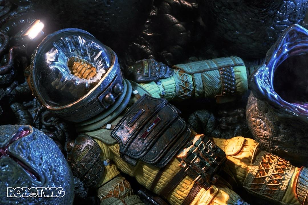 Kane lies still next to the nest of Alien eggs after being attacked by a facehugger that's melting through his spacesuit helmet