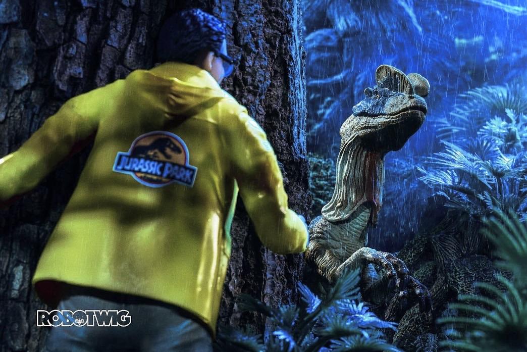 Denis Nedry fastens a rope around a big tree a Dilophosaurus peers from behind the tree