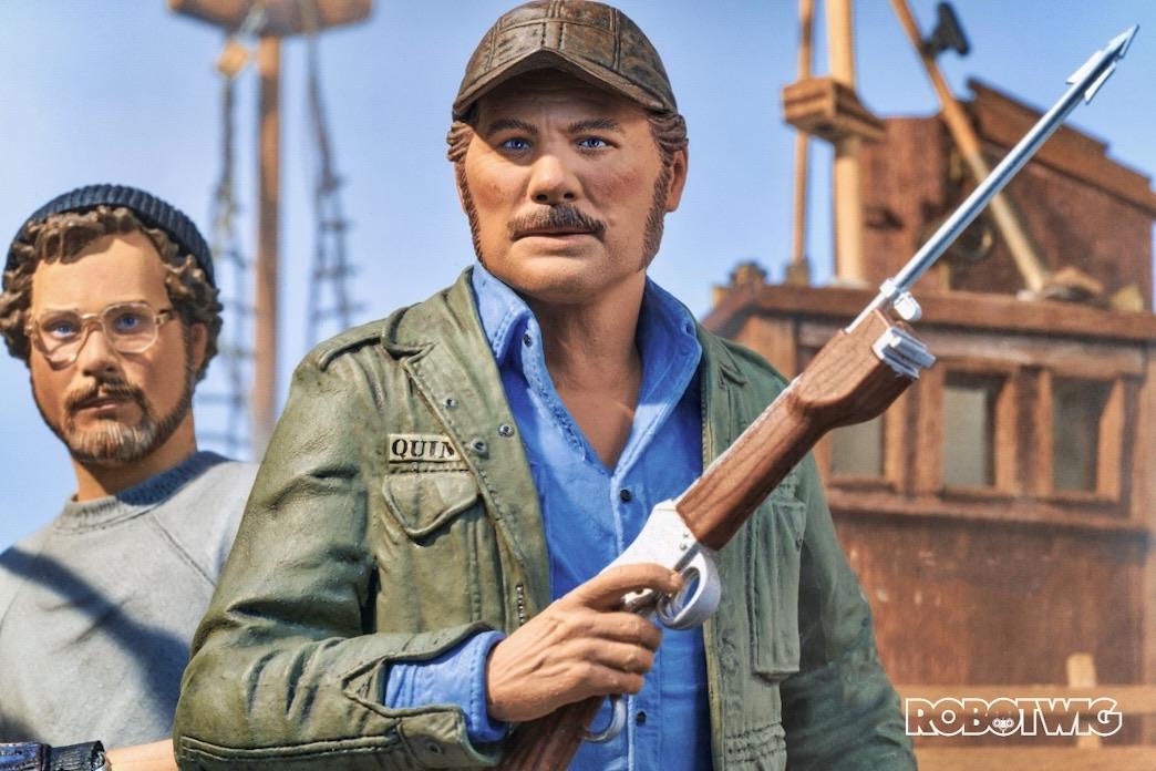 Quint holds a Harpoon looking out on the ocean, Hopper stands behind him looking on