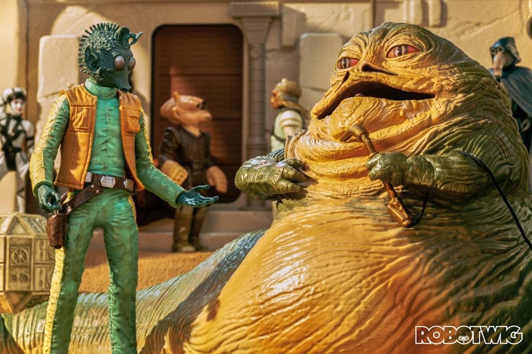 Jabba talks to Greedo in a busy street in Mos Eisley