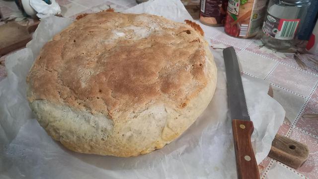 A loaf of atomically hot bread cooling on the kitchen table.