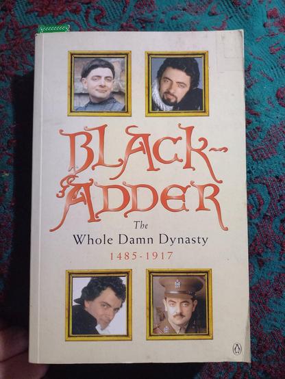 Front cover of Blackadder, The Whole Damn Dynasty (1485 - 1917), Penguin Books, 1999, featuring promotional stills from the four Blackadder series.