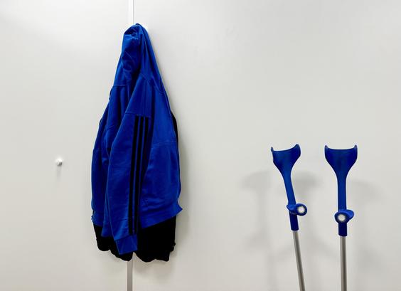 Trainingsjacke und Krücken an der Wand.