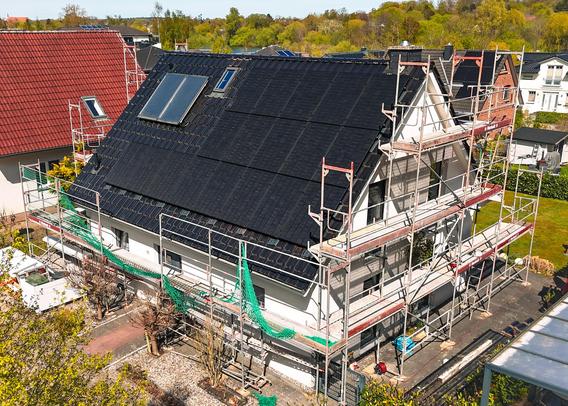 Haus mit Baugerüst bei der Installation der PV-Anlage