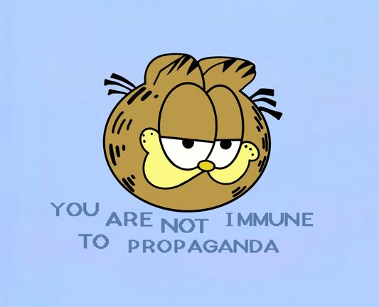 A cartoon of Garfield the Cat’s head on a lilac background. Beneath the head is written: You are not immune to propaganda.
