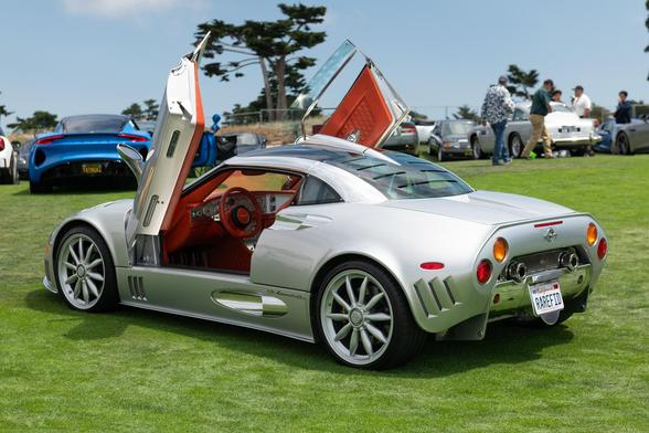 A silver exotic coupe with scissor doors.