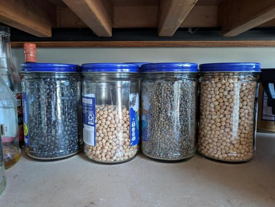 Jars of dried beans in the Adams peanut butter jars, left to right: black beans, chickpeas, green lentils, chickpeas.