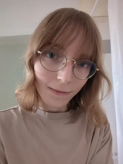 Selfie before the haircut. My hair is naturally pale brown and slightly wavy but not as much as after styling. It's approximately shoulder-length (slightly less) because of the reduced waviness. Also my bangs are way longer, reaching into my field of view, so I slightly swept them to each side.