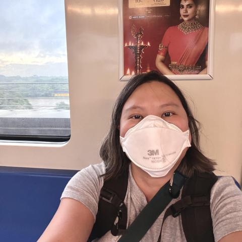 Self id an Asian woman wearing a N95 mask and riding the Chennai metro