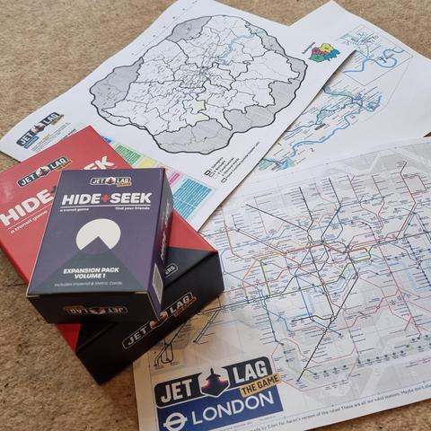 Customised maps of Greater London's transit network alongside a boxed set of Jet Lag: The Game - Hide & Seek and its expansion.