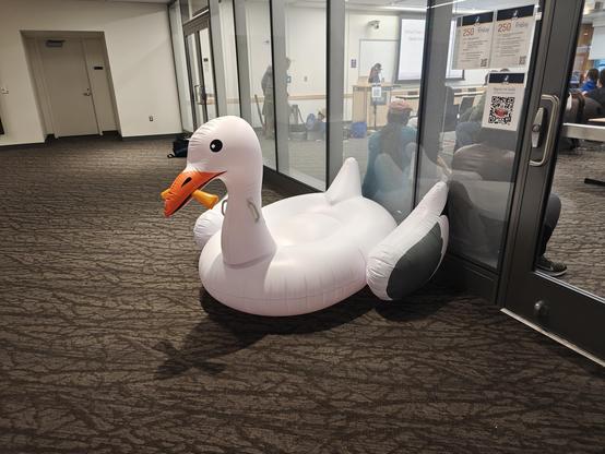 A large inflatable seagull pool floatie with a french fry in their mouth