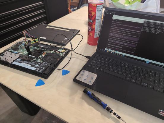 Two laptops, one is a thinkpad getting a bios libreboot update through external flashing. The other laptop is interacting with the flashing device to flash the thinkpad.