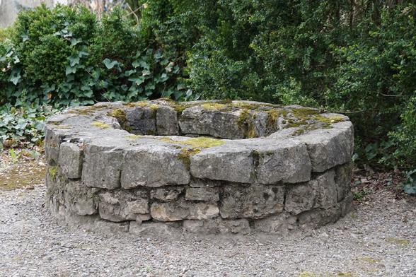 An old well, built out of coarse stones.