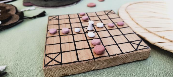 Houten plankje met een spelletje erop.