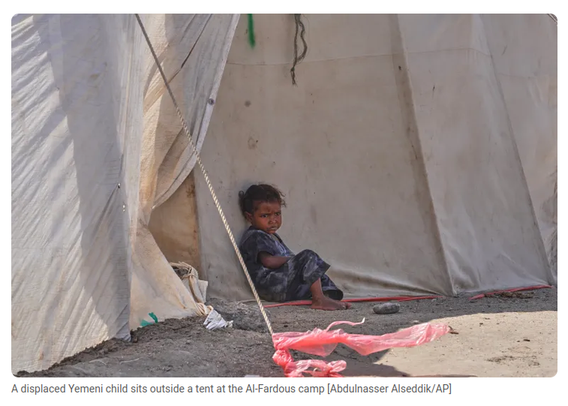 A displaced Yemeni child sits outside a tent at the Al-Fardous camp [Abdulnasser Alseddik/AP]