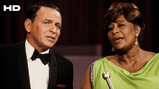This is a picture of Frank Sinatra on the left and Ella Fitzgerald on the right. She is noticeably darker skinned than him because she is black and he is Frank Sinatra