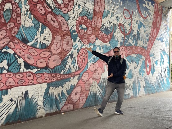 Picture of me in front of a mural with tentacles that form the word „yes“. Consentacles. 