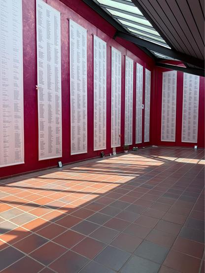 Long strips of cloth inscribed with the names of victims of this concentration camp. There are tens of thousands of names. 