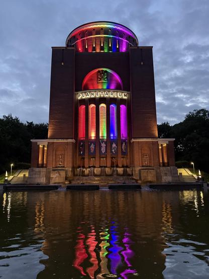 The Hamburg planetarium, an old water tower, lit in pride lights 