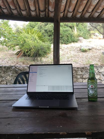 A laptop with Xcode running on a rural Mediterranean terrace 