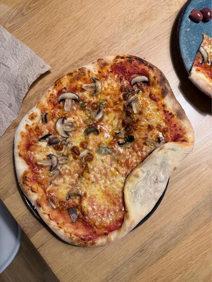 Self made pizza with funghi and a crispy rim 