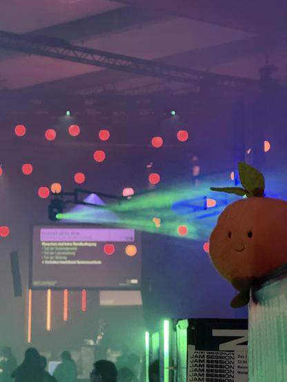 A pink peach plushy plopping in front of the lights 