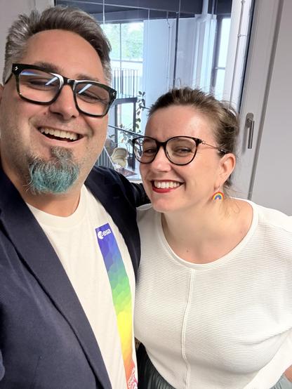 Daniel and Lisa being happy. Daniel has a rainbow shirt and Lisa has rainbow earrings 