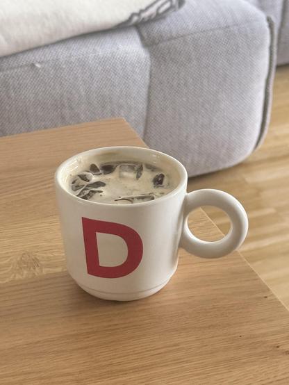 A white cup with ice, water and espresso 