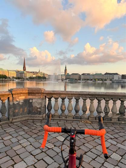 View over my bike handlebars onto the Jungfernstieg, lit by the golden sunset 