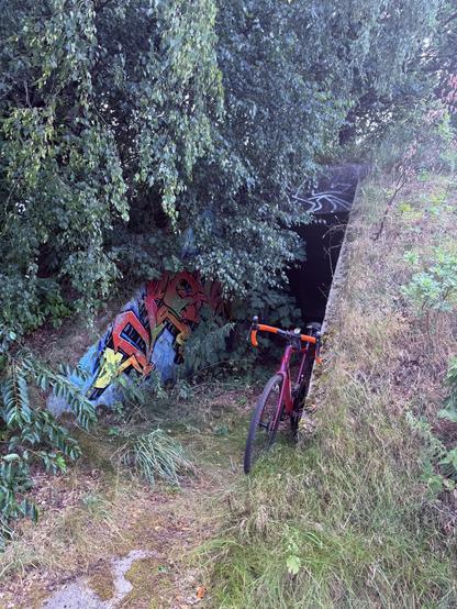 A small bunker with a very pretty bike standing in the entrance 