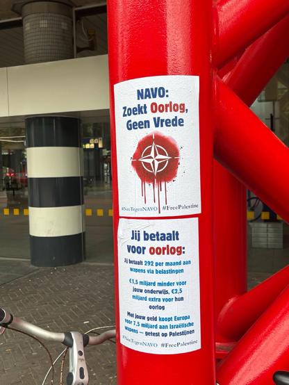 Twee posters met deze tekst:
“Navo zoekt oorlog, geen vrede. Jij betaalt voor oorlog:
Jij betaalt 292 per maand aan wapens via belastingen. €1,5 miljard minder voor jouw onderwijs, €2,5 miljard extra voor hun oorlog. Met jouw geld koopt Europa voor 7,5 miljard aan Israelische wapens, getest op Palestijnen.”