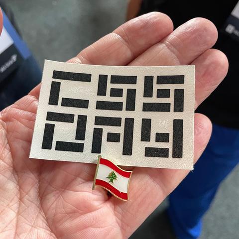 A small pin with the Lebanese flag, combined with a sticker with text: "CSS day"