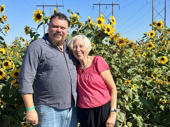 Photo of Jacob and mom Judy dirks in front of sunflowers. 