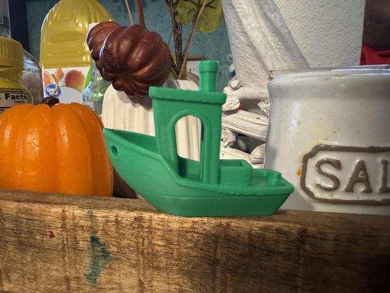 Photo of a green 3D tug boat with thing on my table. 