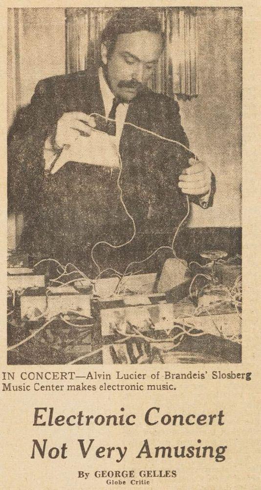 a newspaper clipping showing a photo of Alvin Lucier, resplendent in moustache and suit and tie, holding some wires infront of a bunch of electronic equipment.  he is 35 years old in the photo.  the headline says "Electronic Concert Not Very Amusing"

the description of the photo as described by the paper: "IN CONCERT—Alvin Lucier of Brandeis’ Slosberg Music Center makes electronic music."
the byline says: "By GEORGE GELLES Globe Critic"

the full content of the article is not present in the clipping, only as described above.