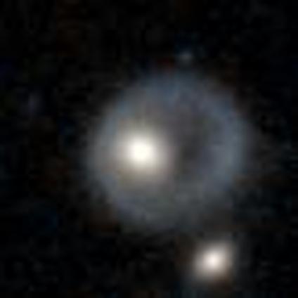 A blurry image of a galactic core perched on the inner side of a pale yellow ring. Best guess is that another galaxy dove through it and formed a ring: https://en.wikipedia.org/wiki/Ring_galaxy A blurry image of a galactic core perched on the inner side of a pale yellow ring. Best guess is that another galaxy dove through it and formed a ring: https://en.wikipedia.org/wiki/Ring_galaxy