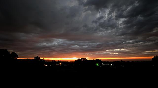 Almost night time just a narrow band of yellow light at the horizon. The clouds look like the rain that doesn't fall.