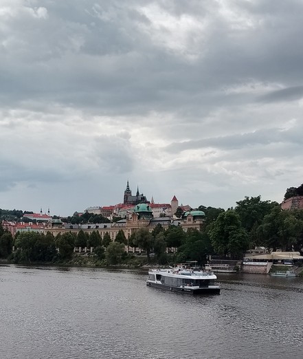Prague Castle, Boat, Vltava. Cloudy sky.
