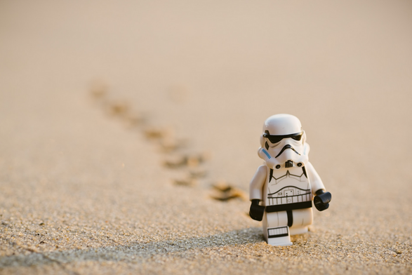A LEGO storm trooper from Star Wars wanders along a sandy gorund